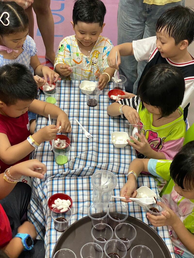 Khoảnh khắc workshop Marshmallow: Bé hào hứng nhúng kẹo vào sốt (Nguồn: DONNA)